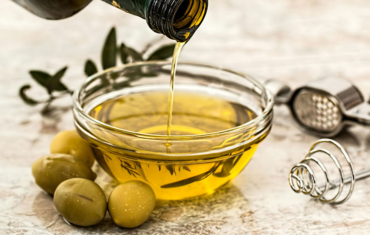 If olives are botanically classified as a fruit, can we say that olive oil is fruit juice? While we may not consume olive oil in the same way that we do apple or orange juice, there’s a reason people have used it for centuries. It’s popular for cooking, as a skin moisturizer, to strengthen hair, and even as a remedy for sore throats and wounds. You might think this “green gold” is a much less healthy counterpart to your morning fruit juice. However, olive oil has been shown to provide many health benefits if you consume it regularly. Health benefits of olive oil Olive oil has various health benefits. The majority of the fats in olive oil are made up of monounsaturated fatty acids (MUFAs). These have been shown to increase levels of “good” cholesterol (HDL) while lowering “bad” cholesterol (LDL). Out of all plant-based cooking oils, olive oil has the highest levels of MUFAs. This, along with the anti-inflammatory and antioxidant compounds in olive oil, may reduce plaque buildup in your arteries. It may also help protect your body from harmful chemicals that have been linked to chronic diseases like cancer, autoimmune diseases, and heart disease. Types of olive oils While olive oil has many great benefits, it’s worth noting that different types of olive oils vary in nutritional quality. This is because they have different amounts of beneficial compounds like polyphenols (compounds with anti-inflammatory and antioxidant characteristics) and other antioxidants. Extra virgin olive oil (EVOO) contains the highest percentage of polyphenols and antioxidants. That’s because it goes through a single processing procedure whereas other types are processed more. More processing causes more polyphenols and antioxidants to be lost. Virgin olive oil (VOO) is only slightly more processed than EVOO. It still contains most of the olives’ polyphenolic and antioxidant compounds but not as many as EVOO. VOO is also milder in flavor. Finally, “light,” “pure,” and refined olive oils are more moderately processed. This leads to the mildest flavor, meaning they contain much less of the beneficial compounds. Recommended oil intake The daily recommended intake for oil varies depending on age, sex, and activity level. The 2020-2025 Dietary Guidelines for Americans recommends 27 grams (just under 2 tablespoons) of any type of added oils per day for a 2,000 calorie diet. Ways to add olive oil into your diet Here are some ideas for adding olive oil – to replace other types of fats – into your diet so you can reap its benefits: Use it as a salad dressing: Mix together olive oil, balsamic vinegar and mustard for a simple and delicious salad dressing. Drizzle it over roasted vegetables: Toss your favorite veggies with a bit of olive oil and roast them in the oven for a healthy side dish. Use it for cooking: Olive oil may be used for cooking. The more refined types of olive oil may be heated to a higher temperature than EVOO, though EVOO may be used at lower cooking temperatures. If you want to maintain the integrity of the flavor and quality of the olive oil, use your higher quality EVOO as a finishing oil.